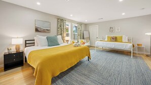 A hotel room with two beds, a large window with curtains, a bedside table with a lamp, and a floor lamp. - Pickleball, Pool, Games, Mins to Zilker, SoCo/DT (Austin)