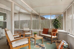 A sunroom with a wooden bench, two chairs, a small table, and a potted plant. - Pickleball, Pool, Games, Mins to Zilker, SoCo/DT (Austin)