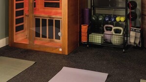 A room with a wooden sauna, a neon sign reading 'MOVEMENT IS MEDICINE,' and a rack with kettlebells and dumbbells. - Pool, Mini-golf, Sauna, Movie, Gym | Sleep 18 (Austin)
