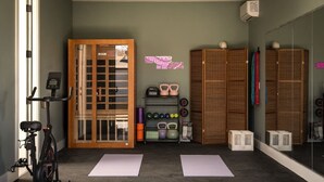 A gym with exercise equipment, mats, and storage cabinets. - Pool, Mini-golf, Sauna, Movie, Gym | Sleep 18 (Austin)