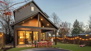 A modern house with a covered patio, a swimming pool, and a well-maintained lawn. - Pool, Mini-golf, Sauna, Movie, Gym | Sleep 18 (Austin)