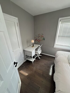 Ein Schlafzimmer mit einem Bett, einem Schreibtisch und einem Fenster.