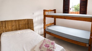Een eenpersoonsbed met houten hoofdeinde en een stapelbed met matras.