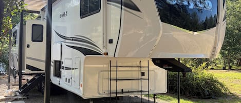 Una caravana Jayco Eagle Series con una zona de estar cubierta, una cocina y un espacio para dormir.