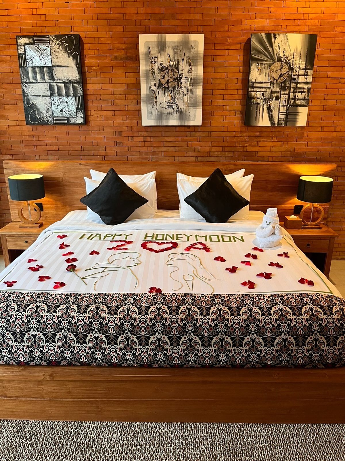 Una habitación de hotel con una cama, dos mesitas de noche y una obra de arte en la pared.