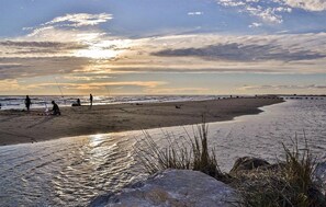 A beach with people fishing, calm water, and a sunset. - 3 bedroom lovely home in Salin de Giraud (Salin de Giraud)