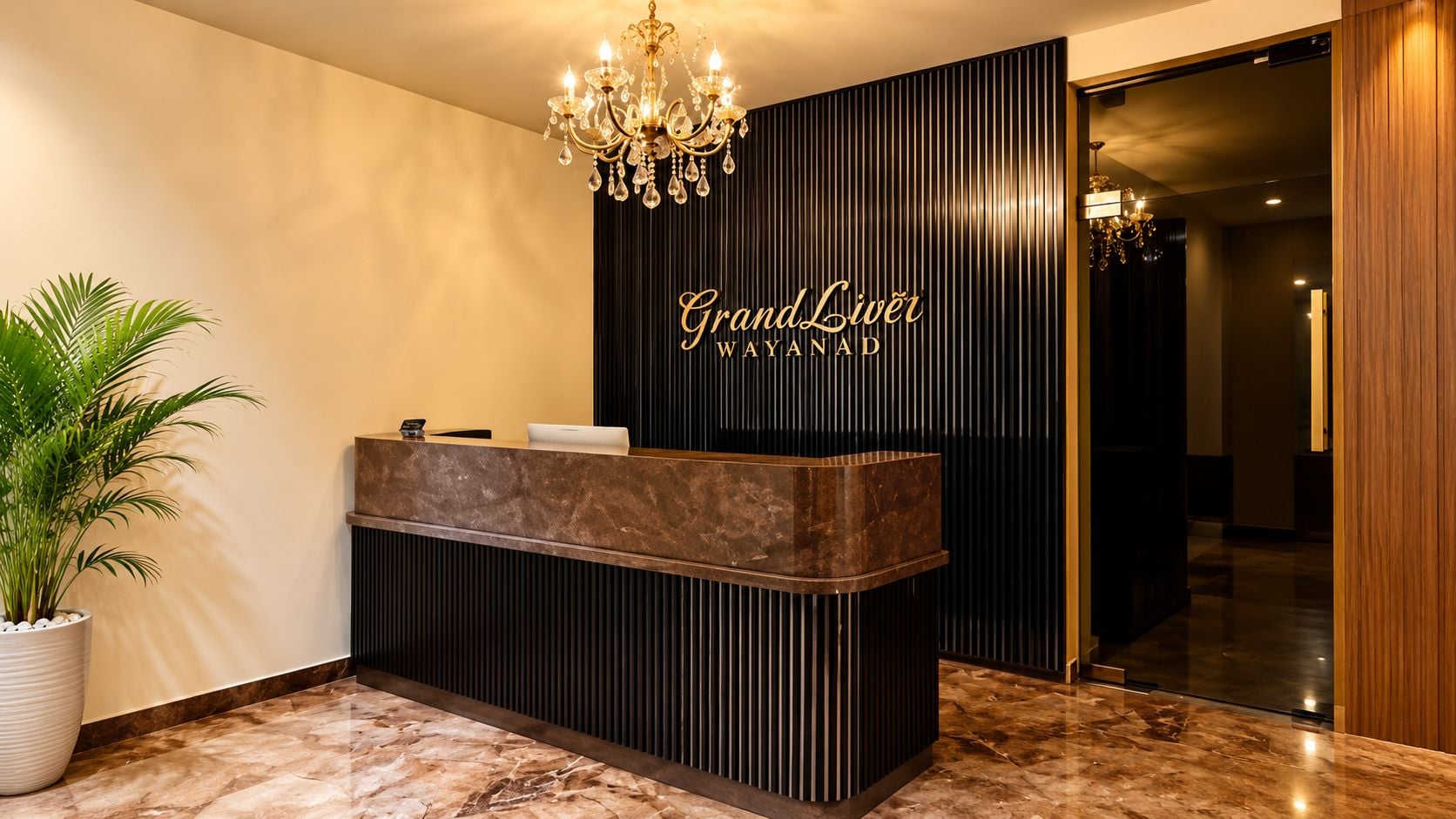 A reception desk with a modern design, a chandelier, and a potted plant.