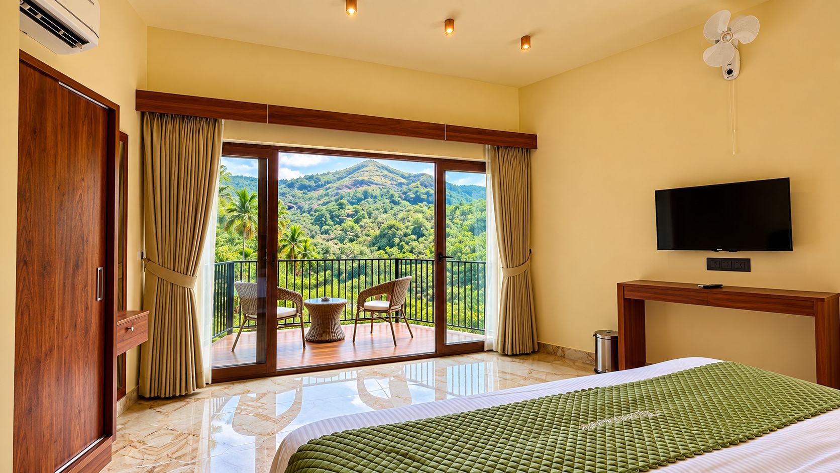 Habitación de hotel con balcón, cama, televisor y vistas a un paisaje montañoso.