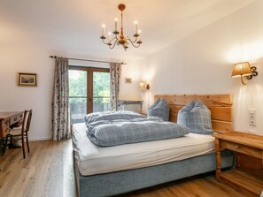 A bedroom with a bed, a wooden nightstand, a desk, and a chair. - Apartment, 800m to Hahnenkamm & ski lift (Kitzbühel)