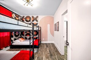 A dormitory room with bunk beds, a patterned wall, and a hallway. - The Encore - Rooftop Hot Tub/Game Room/Sleeps 12 (Nashville)