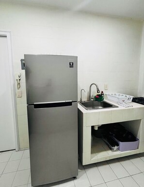 A compact kitchen with a stainless steel refrigerator, a sink, and a small countertop. - 2-bedroom apartment in vibrant Ciudad de Mexico Roma Norte (Ciudad de México)