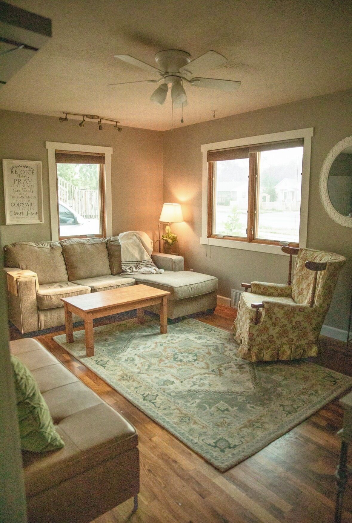 Una sala de estar con sofá, sillón, mesa de centro y alfombra.