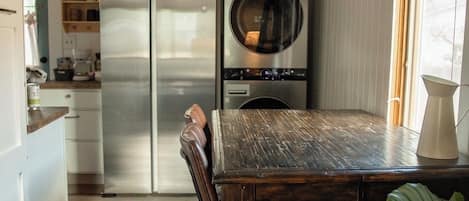 Eine Küche mit einem Holztisch, einem Kühlschrank und einem eingebauten Backofen.