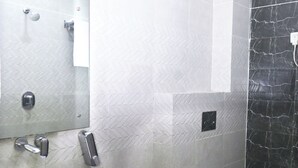A bathroom with a white sink, a toilet, and a shower area.
