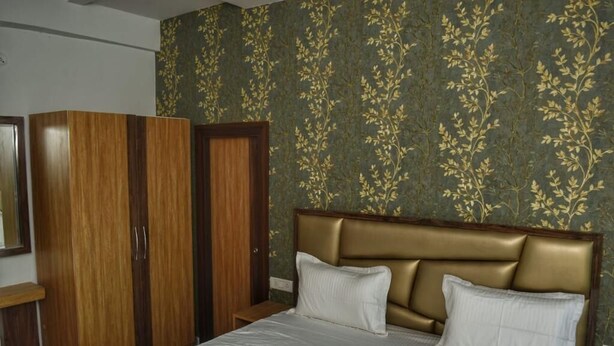 A bedroom with a bed, a wardrobe, and a nightstand.