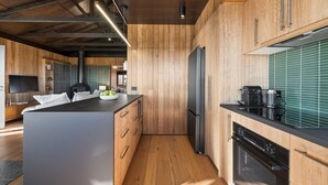 Una cocina moderna con armarios de madera, una isla central y un horno empotrado.