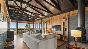 Una sala de estar moderna con sofá, televisor, chimenea y estanterías.
