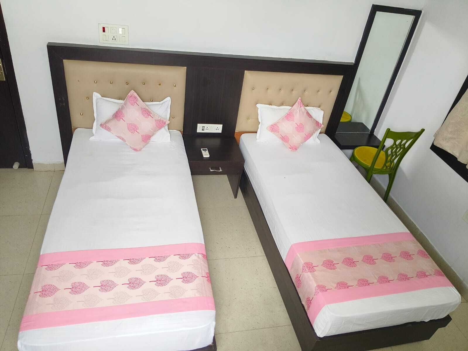 A double bed room with a headboard, bedside tables, a mirror, and a chair.