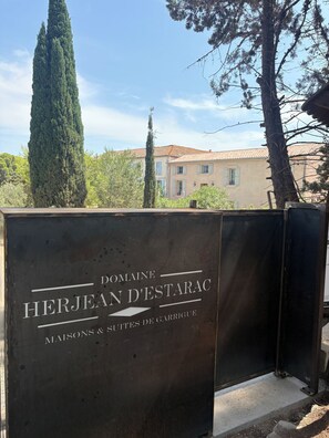 A sign for Domaine Herjean D'Estarac with the text 'MAISONS & SITES DE GARRIGUE' indicating a property with houses and sites. - Maison de Garrigue Estanh – A charming estate with a pool near Narbonne (Bages)