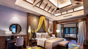 A modern hotel room with a large bed, a desk, and a seating area.