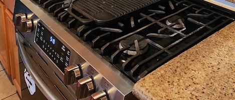 A kitchen with a stainless steel stove, a toaster, and a coffee maker on the countertop.