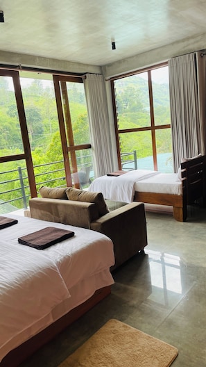 A hotel room with two beds, a sofa, and large windows offering a view of greenery. - Wild Resort Ella (Ella)