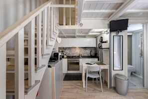 A compact kitchen with a dining area, a small table, and a chair. - ‘Ludo Home - Rome’ Apartment with Wi-Fi and Air Conditioning (Rome)