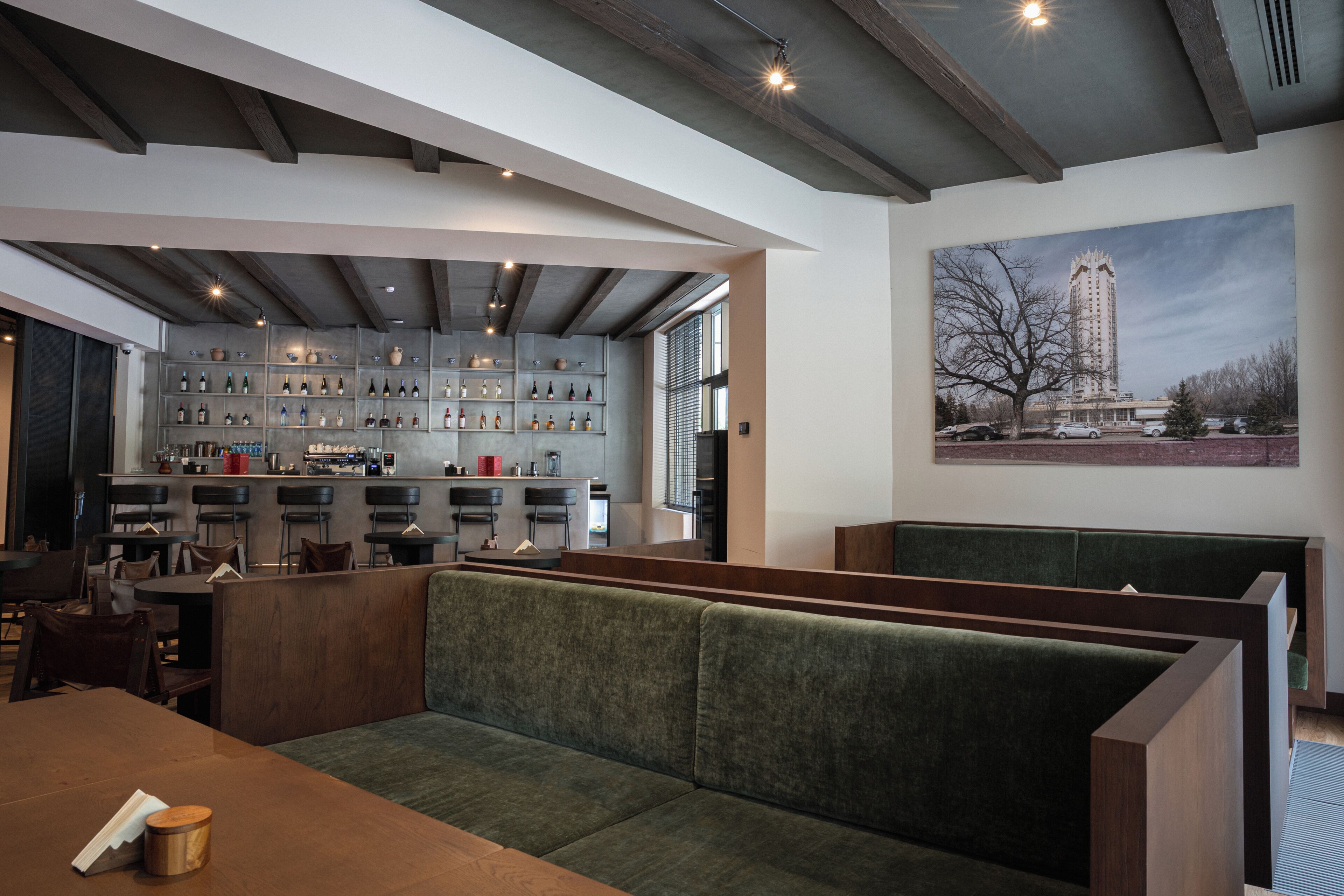 Ein Restaurant mit Bar, Sitzgelegenheiten und einem großen Fenster.