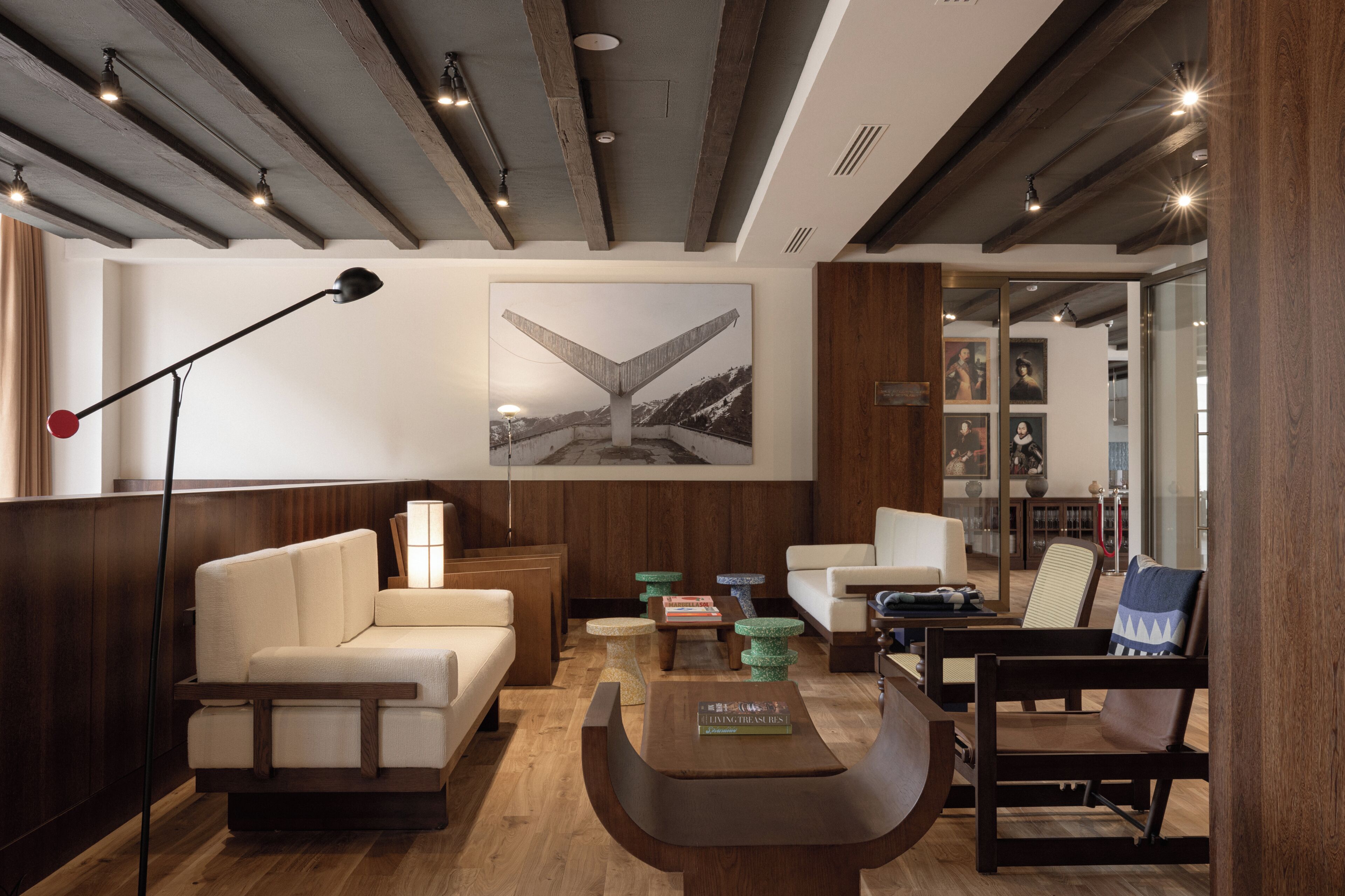 A modern hotel lobby with a sofa, armchair, coffee table, and a floor lamp.