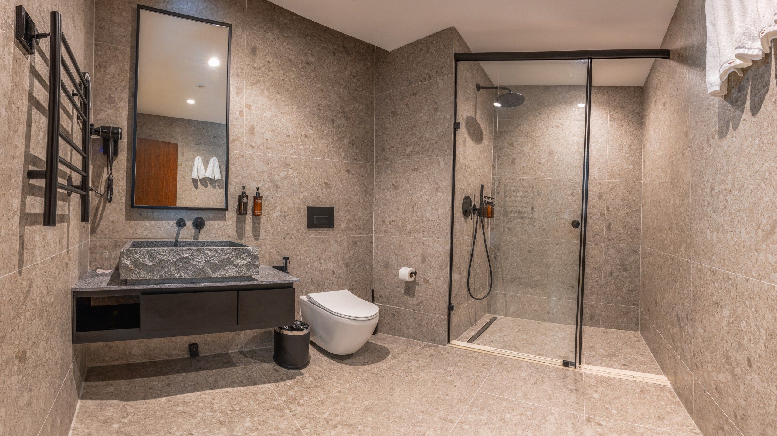 Un baño moderno con ducha, inodoro y lavamanos.