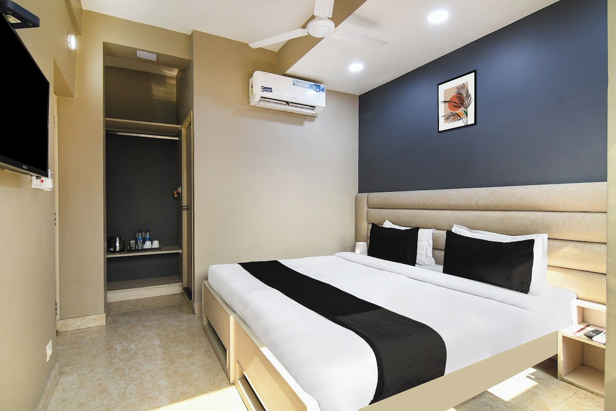 A hotel room with a bed, bedside table, nightstand, and a ceiling fan.