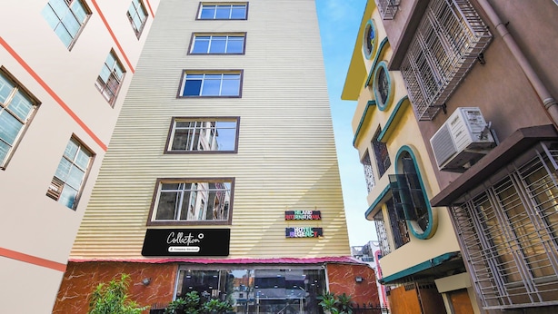 Un immeuble à plusieurs étages portant une enseigne indiquant « Collection Company-Serviced » et « Hiland International Hotel Regency ».