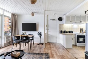 Eine moderne Wohnung mit Essbereich, Küche und einem großen Fenster.