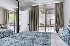 A hotel room with two beds, a balcony, and a view of the outdoor area. - Modern Apartment with Free Parking | Wi-Fi | Netflix | 5km to CBD & Glenelg (Plympton)