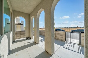 A covered outdoor area with a tiled floor, a metal fence, and a view of the street. - 20% OFF Luxury 3BR Home, Modern Design & Comfort (Ontario)