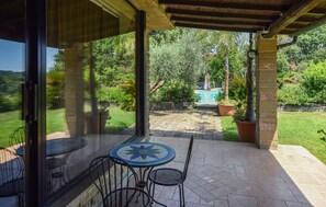 A covered patio with a mosaic table and chairs, a pool, and lush greenery in the background. - Stunning home in Canale Monterano (Canale Monterano)