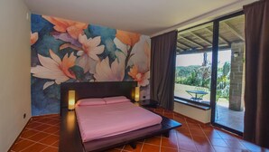 A bedroom with a bed, a large floral mural, a window with curtains, and a view of greenery outside. - Stunning home in Canale Monterano (Canale Monterano)