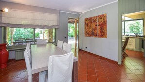 A dining area with a large table and chairs, a red vase, and a view of the outdoors. - Stunning home in Canale Monterano (Canale Monterano)