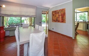 A dining area with a large table and chairs, a red vase, and a view of the outdoors. - Stunning home in Canale Monterano (Canale Monterano)