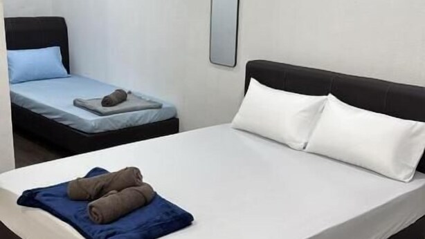 A hotel room with a large bed, a smaller bed, and a mirror on the wall. - JSW PRAMLee (George Town)