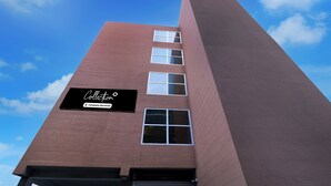 Un edificio alto in mattoni con un cartello che riporta la scritta 'Collectivo Company-Serviced'.