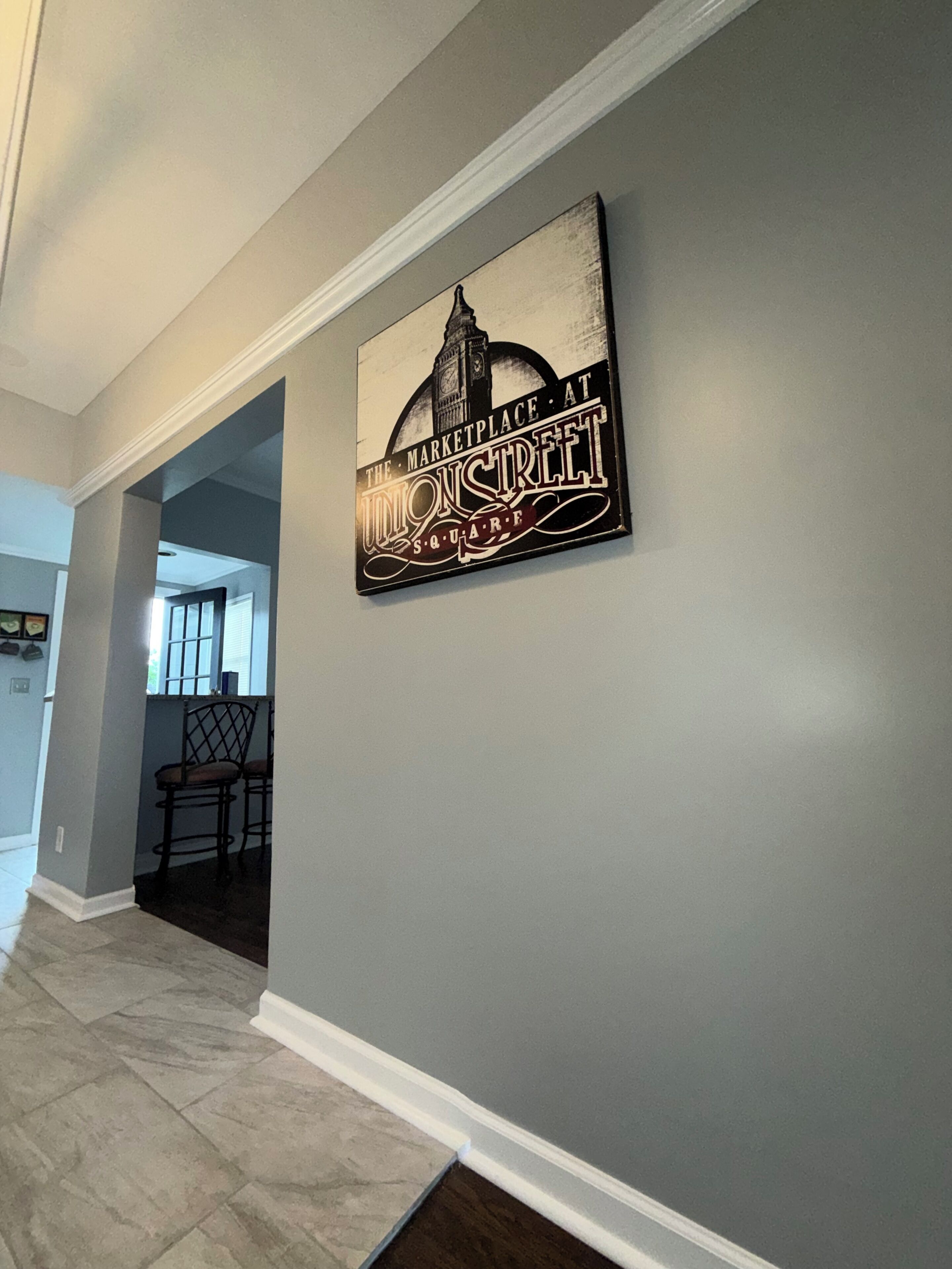 A hallway with a wall-mounted sign featuring a building silhouette and text.
