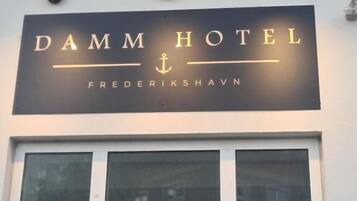 A hotel sign with the name 'DAMM HOTEL' and the location 'FREDERIKSHAVN'.