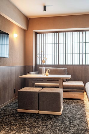 A modern room with a large window, a table, and seating. - Apartment Hotel 11 Gion (Kyoto-shi)