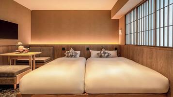 A room with a bed, a small table with a vase, and a sofa.