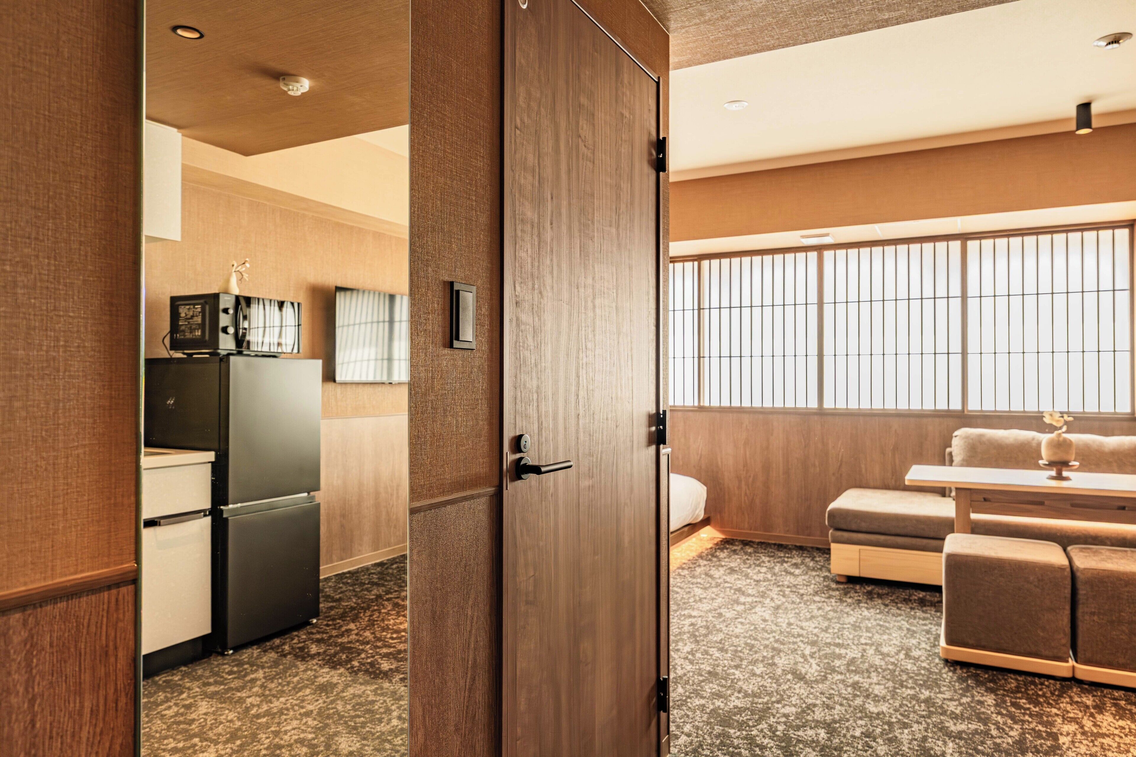 Ein Hotelzimmer mit einer Küchenzeile, einer Sitzecke und einem großen Fenster.