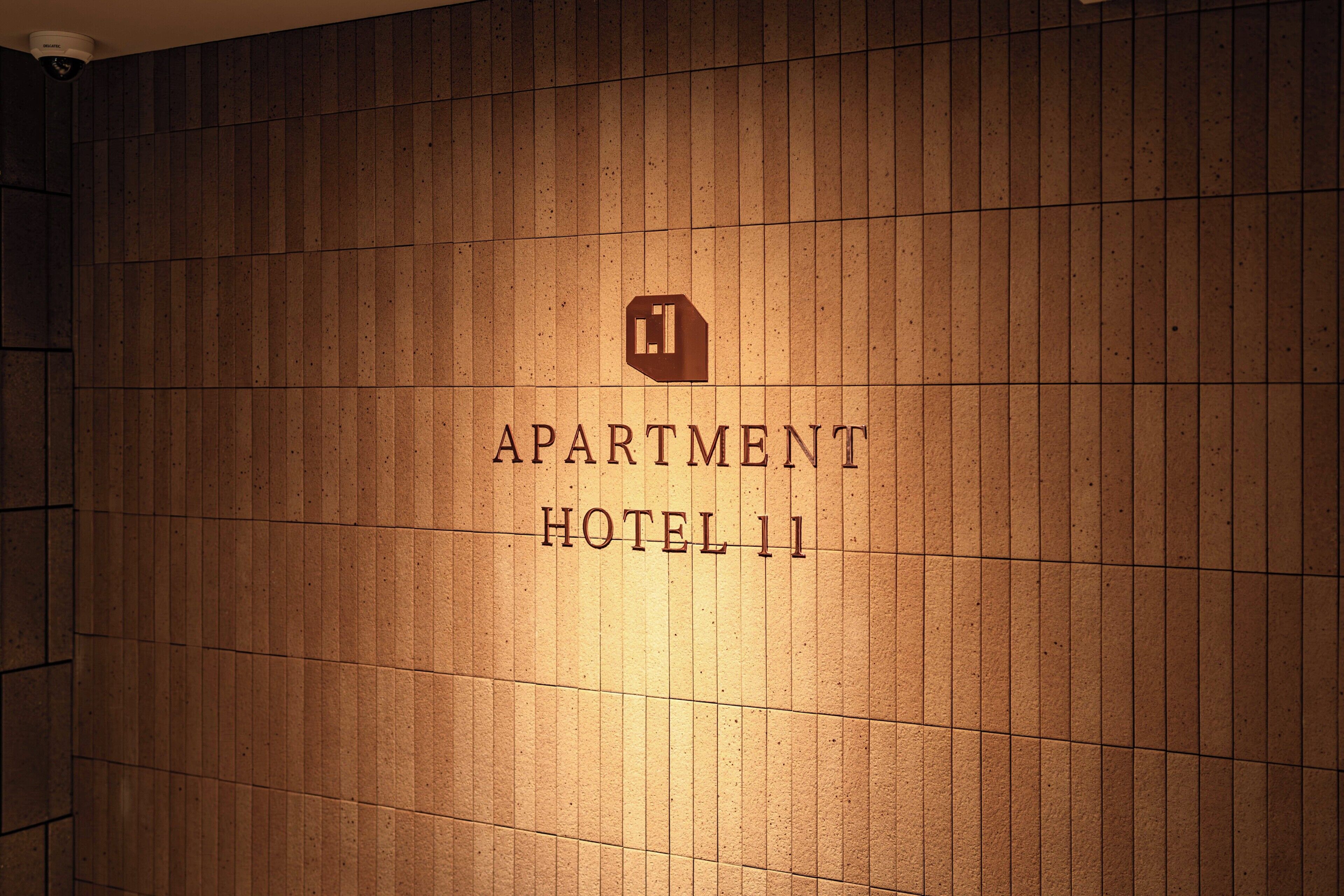 A wall with the text 'APARTMENT HOTEL 11' and a logo above it.