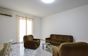 Ein Wohnzimmer mit einer Couch, einem Sessel und einem kleinen Tisch.