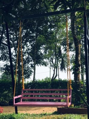 A swing set in a park with a bench. - Happy Feet Wayanad (Sulthan Bathery)