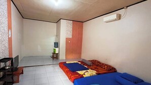 Une chambre avec deux lits, une télévision et un distributeur d’eau.